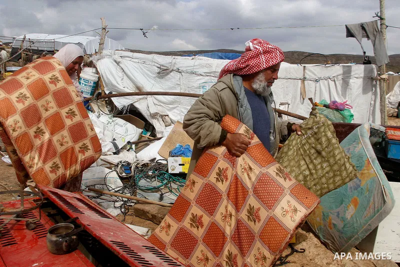 Palestinians collect items from their home after it was demolished by Israeli bulldozers in a disputed military zone in the area of Musafir Jenbah, which includes several villages, south of the West Bank town of Hebron o...