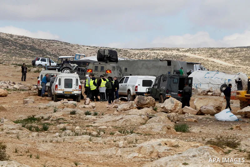 Israeli security forces stand guard during Israeli bulldozers demolish Palestinian homes in a disputed military zone in the area of Musafir Jenbah, which includes several villages, south of the West Bank town of Hebron o...