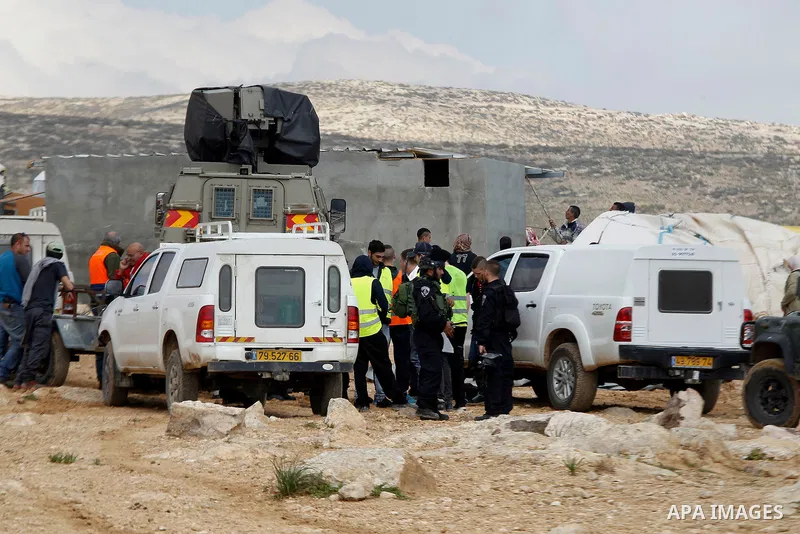 Israeli security forces stand guard during Israeli bulldozers demolish Palestinian homes in a disputed military zone in the area of Musafir Jenbah, which includes several villages, south of the West Bank town of Hebron o...