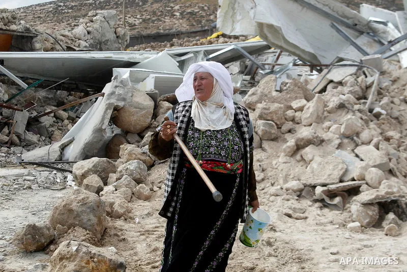 A Palestinian woman stands next on the remains of her home after it was demolished by Israeli bulldozers in a disputed military zone in the area of Musafir Jenbah, which includes several villages, south of the West Bank...