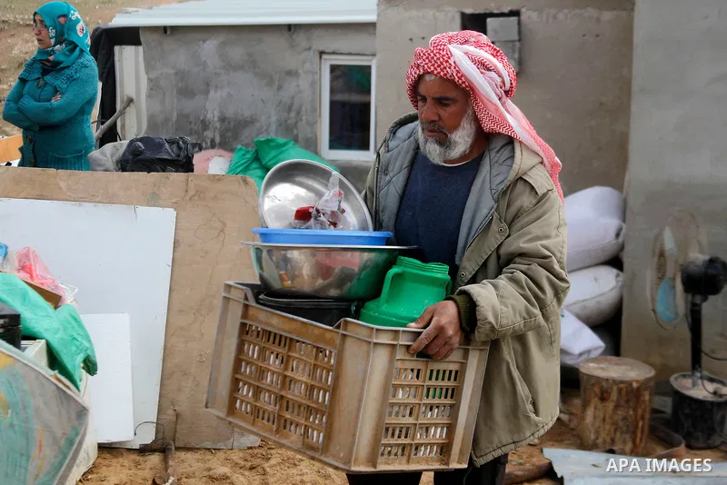 A Palestinian man collects items from his home after it was demolished by Israeli bulldozers in a disputed military zone in the area of Musafir Jenbah, which includes several villages, south of the West Bank town of Hebr...