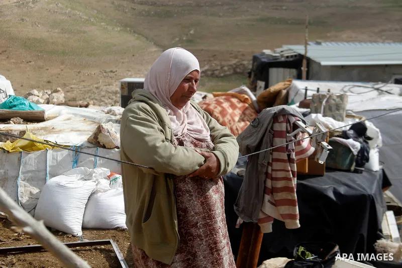 A Palestinian woman stands next on the remains of her home after it was demolished by Israeli bulldozers in a disputed military zone in the area of Musafir Jenbah, which includes several villages, south of the West Bank...
