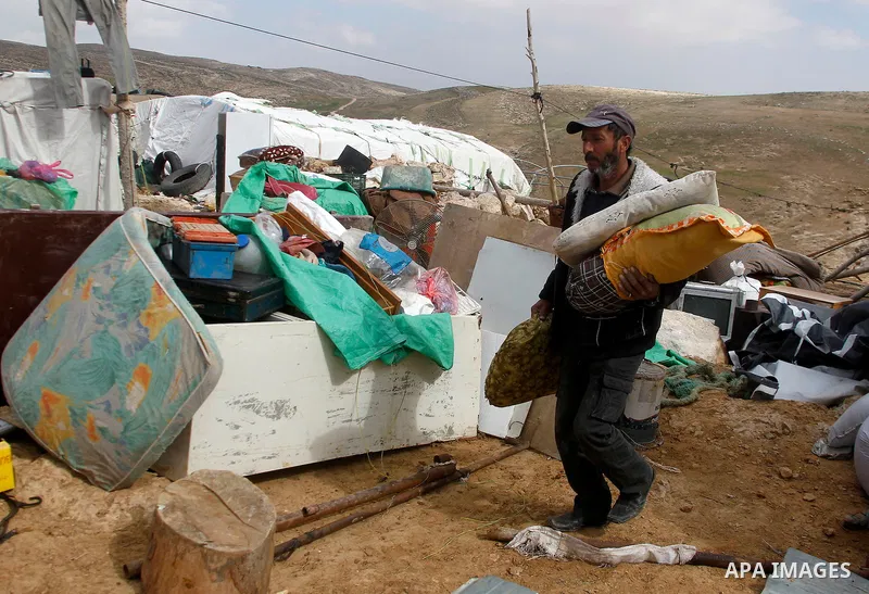 A Palestinian man collects items from his home after it was demolished by Israeli bulldozers in a disputed military zone in the area of Musafir Jenbah, which includes several villages, south of the West Bank town of Hebr...