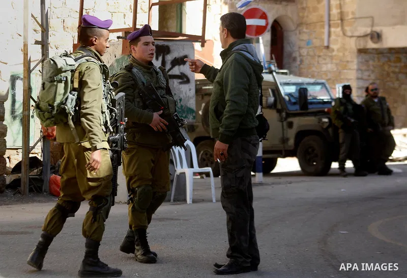 Israeli army soldiers stand gaurd in front of houses which Israeli settlers try to take over, in the West Bank city of Hebron, 03 February 2016. The building is near the religious site known to Jews as the Cave of the Pa...