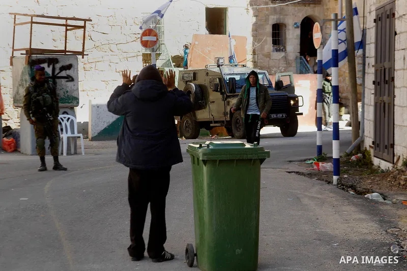 Israeli army soldiers check a Palestinian man in front of houses which Israeli settlers try to take over, in the West Bank city of Hebron, 03 February 2016. The building is near the religious site known to Jews as the Ca...