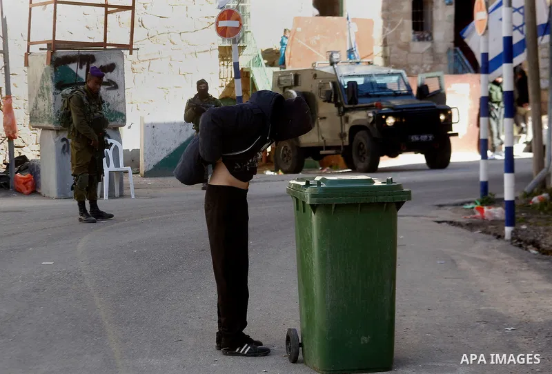 Israeli army soldiers check a Palestinian man in front of houses which Israeli settlers try to take over, in the West Bank city of Hebron, 03 February 2016. The building is near the religious site known to Jews as the Ca...