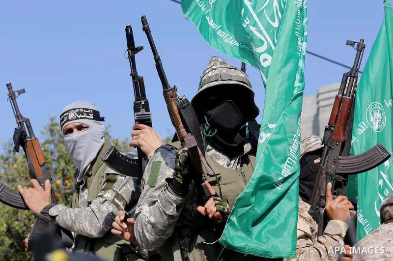 Palestinian members of the Ezzedine al-Qassam Brigades, the armed wing of the Hamas movement mourn during the funeral of fellow militant Ahmed al-Zahar in the village of Al-Moghraga near the Nuseirat refugee camp in the...