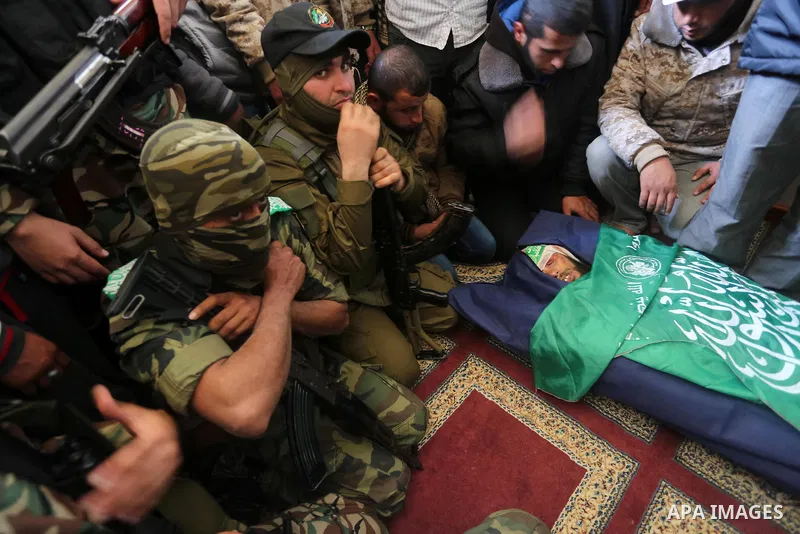 Palestinian militants mourn around the body of Fuad Abu Atewi, who was killed when a tunnel collapse on Tuesday, mourn during his funeral in the village of Al-Moghraga near central Gaza Strip, February 3, 2016. The colla...