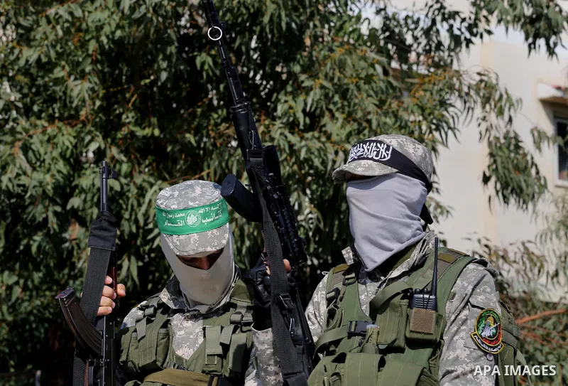 Palestinian members of the Ezzedine al-Qassam Brigades, the armed wing of the Hamas movement mourn during the funeral of fellow militant Ahmed al-Zahar in the village of Al-Moghraga near the Nuseirat refugee camp in the...