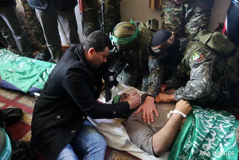Palestinian militants mourn around the body of Ahmed al-Zahar, who was killed when a tunnel collapse on Tuesday, mourn during his funeral in the village of Al-Moghraga near central Gaza Strip, February 3, 2016. The colla...