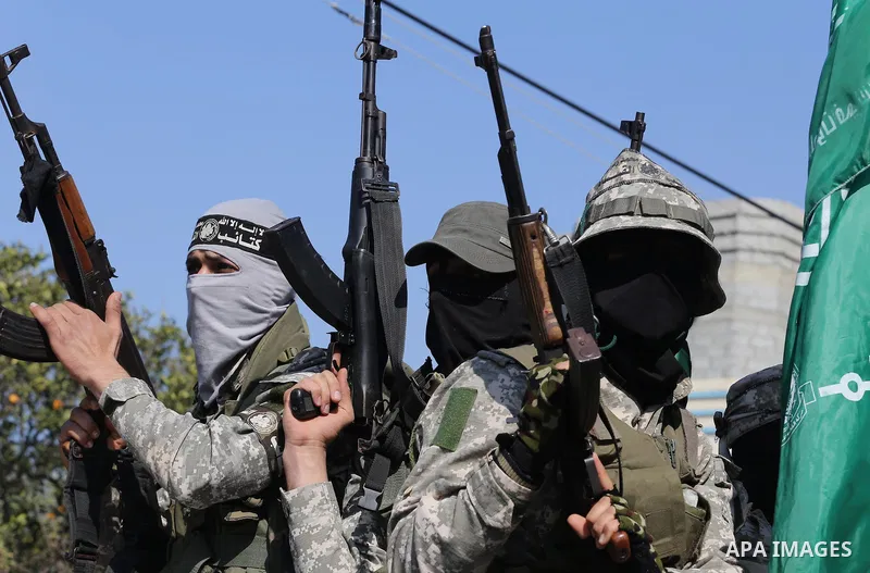 Palestinian members of the Ezzedine al-Qassam Brigades, the armed wing of the Hamas movement mourn during the funeral of fellow militant Ahmed al-Zahar in the village of Al-Moghraga near the Nuseirat refugee camp in the...
