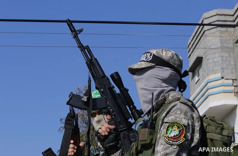 Palestinian members of the Ezzedine al-Qassam Brigades, the armed wing of the Hamas movement mourn during the funeral of fellow militant Ahmed al-Zahar in the village of Al-Moghraga near the Nuseirat refugee camp in the...