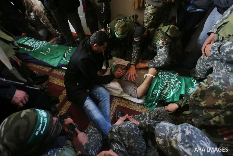 Palestinian militants mourn around the body of Ahmed al-Zahar, who was killed when a tunnel collapse on Tuesday, mourn during his funeral in the village of Al-Moghraga near central Gaza Strip, February 3, 2016. The colla...