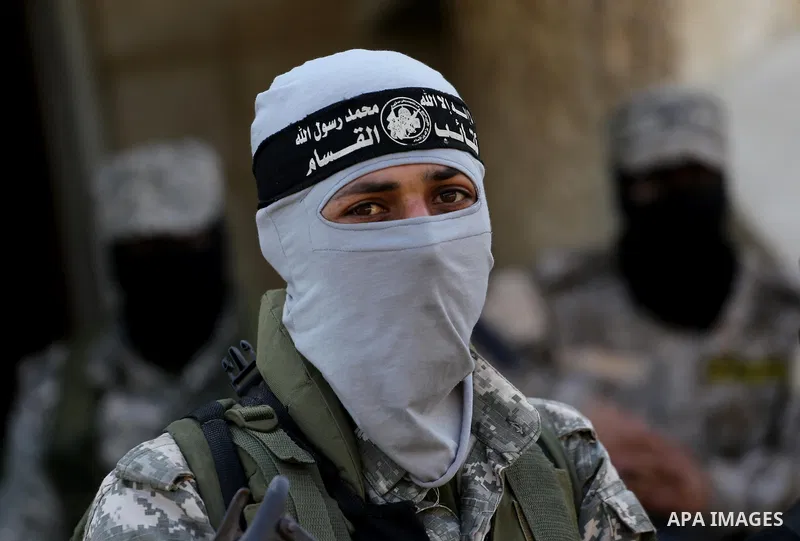 Palestinian members of the Ezzedine al-Qassam Brigades, the armed wing of the Hamas movement mourn during the funeral of fellow militant Ahmed al-Zahar in the village of Al-Moghraga near the Nuseirat refugee camp in the...