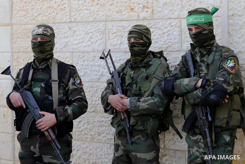 Palestinian members of the Ezzedine al-Qassam Brigades, the armed wing of the Hamas movement mourn during the funeral of fellow militant Ahmed al-Zahar in the village of Al-Moghraga near the Nuseirat refugee camp in the...