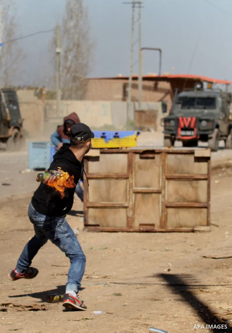 A Palestinian protester throws a molotov cocktail at Israeli security forces during clashes in Qabatiya, a town near Jenin in the north of the Israeli-occupied West Bank, on February 4, 2016. Israeli forces locked down Q...
