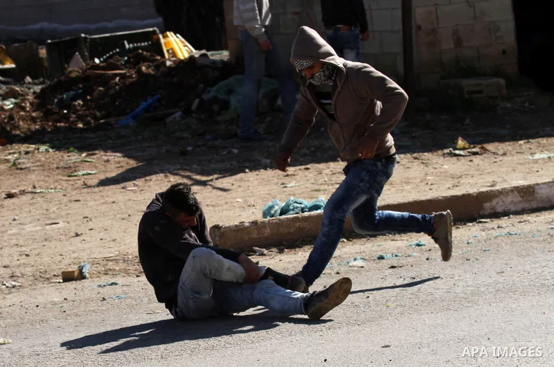 A wounded Palestinian youth lies on the ground during clashed with Israeli security forces in Qabatiya, a town near Jenin in the north of the Israeli-occupied West Bank, on February 4, 2016. Israeli forces locked down Qa...