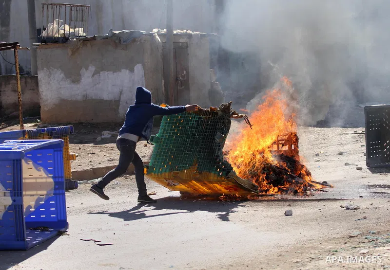 A Palestinian protester burns tires during clashes with Israeli security forces in Qabatiya, a town near Jenin in the north of the Israeli-occupied West Bank, on February 4, 2016. Israeli forces locked down Qabatiya that...