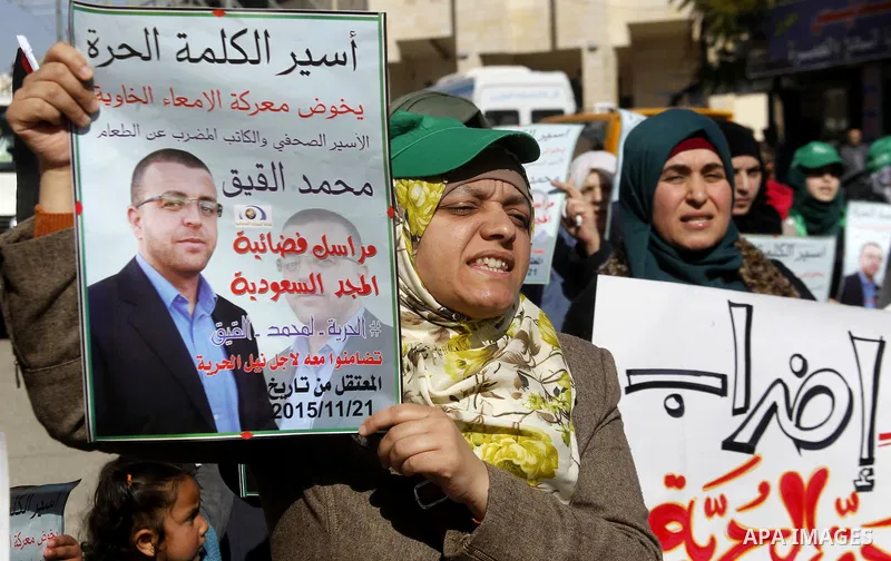 Palestinian demonstrators hold posters bearing portraits of Palestinian journalist Mohammed al-Qiq who is imprisoned in an Israeli jail during a protest in support of his hunger strike in the West Bank city of Hebron on...