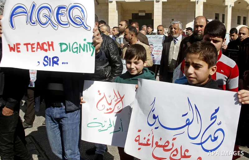 Palestinian demonstrators hold posters bearing portraits of Palestinian journalist Mohammed al-Qiq who is imprisoned in an Israeli jail during a protest in support of his hunger strike in the West Bank city of Hebron on...