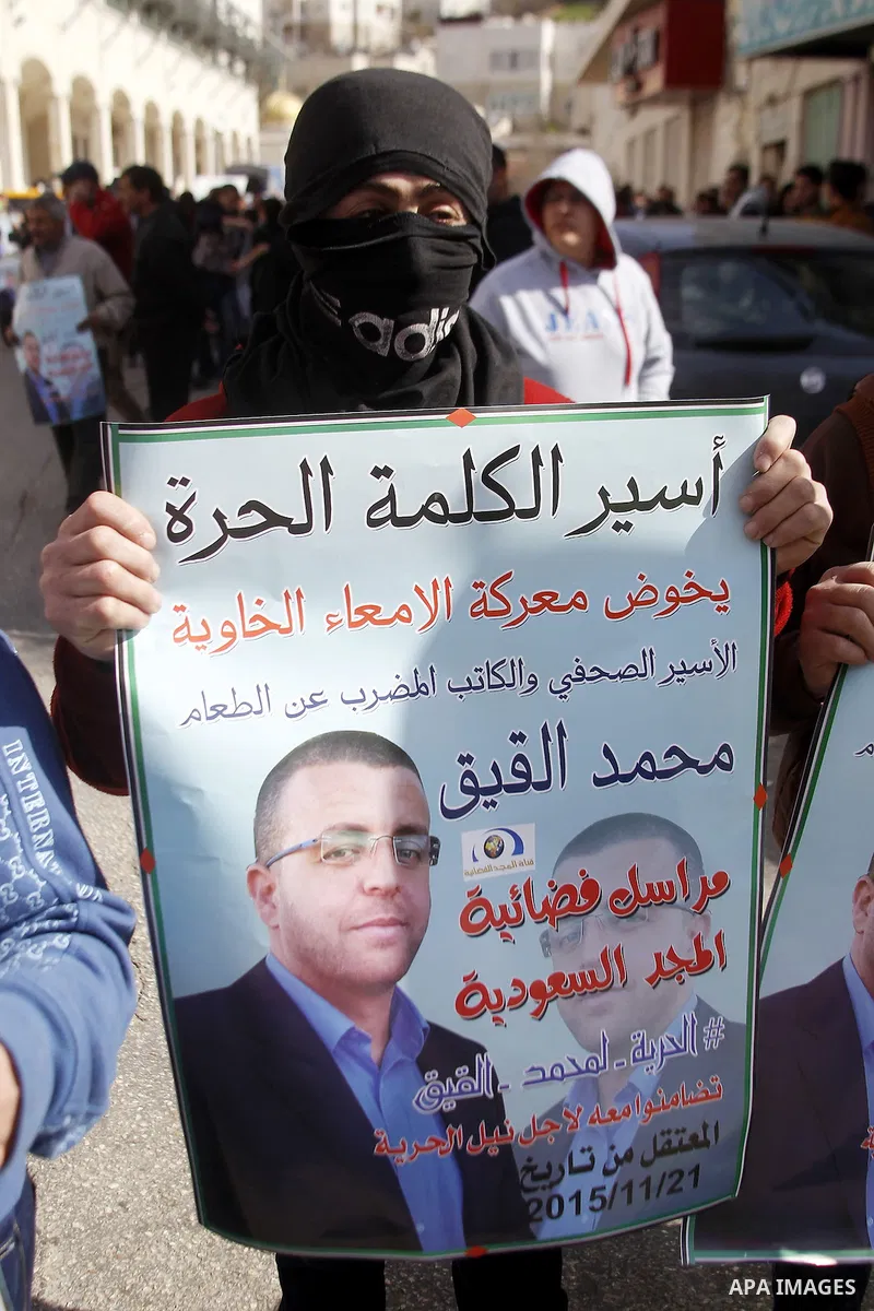 Palestinian demonstrators hold posters bearing portraits of Palestinian journalist Mohammed al-Qiq who is imprisoned in an Israeli jail during a protest in support of his hunger strike in the West Bank city of Hebron on...