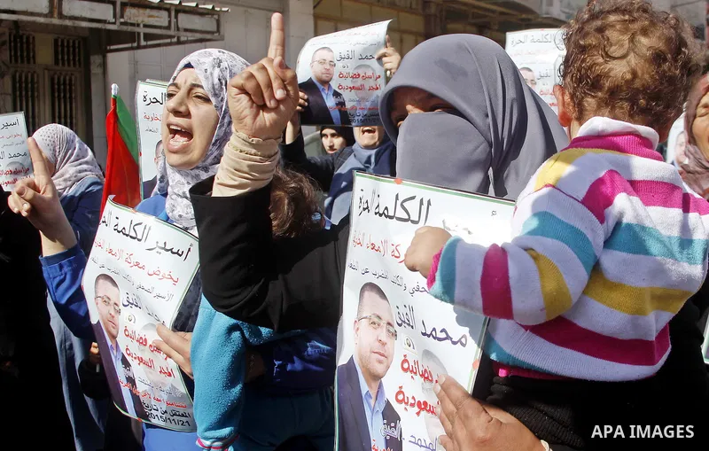 Palestinian demonstrators hold posters bearing portraits of Palestinian journalist Mohammed al-Qiq who is imprisoned in an Israeli jail during a protest in support of his hunger strike in the West Bank city of Hebron on...