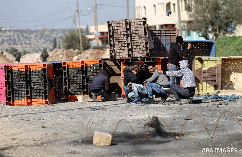 A Palestinian protester throws stones towards Israeli security forces during clashes in the Palestinian town of Qabatiya, near Jenin in the north of the Israeli-occupied West Bank, on February 5, 2016. The Israeli army b...