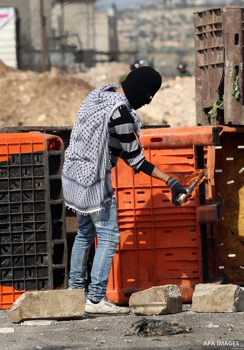 A Palestinian protester hurls a molotov cocktail towards Israeli security forces during clashes in the Palestinian town of Qabatiya, near Jenin in the north of the Israeli-occupied West Bank, on February 5, 2016. The Isr...