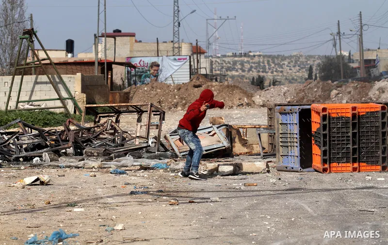 A Palestinian protester throws stones towards Israeli security forces during clashes in the Palestinian town of Qabatiya, near Jenin in the north of the Israeli-occupied West Bank, on February 5, 2016. The Israeli army b...