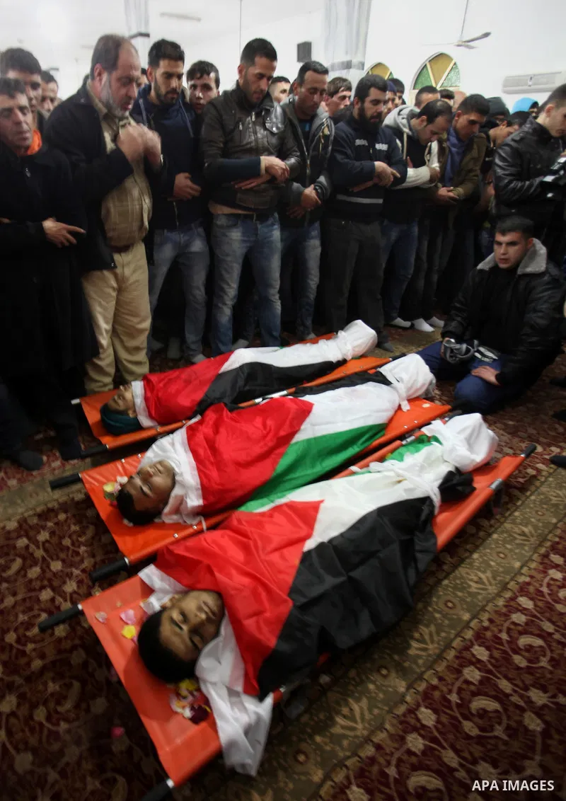 Mourners pray next to the bodies of three Palestinians who were killed by Israeli security forces as they carried out a deadly attack in Jerusalem, during their funeral in the village of Qabatiya, near the West Bank city...
