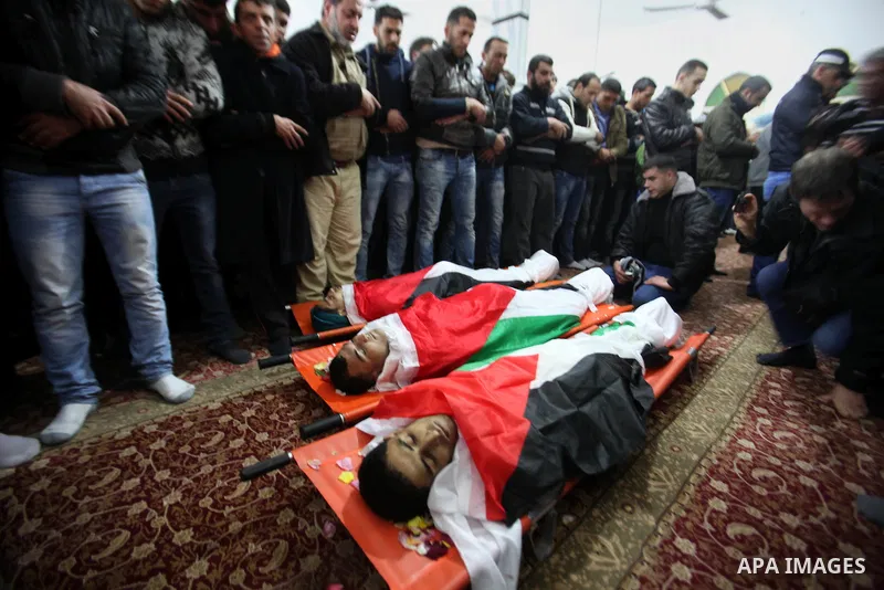 Mourners pray next to the bodies of three Palestinians who were killed by Israeli security forces as they carried out a deadly attack in Jerusalem, during their funeral in the village of Qabatiya, near the West Bank city...
