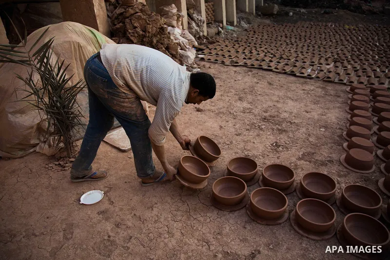 An Egyptian man works at a pottery workshop in Cairo, on February 6, 2016. Pottery is an ancient and traditional craft in Gaza. Local workshops usually produce products such as bowls, pitchers, flower pots, and vases. Ph...