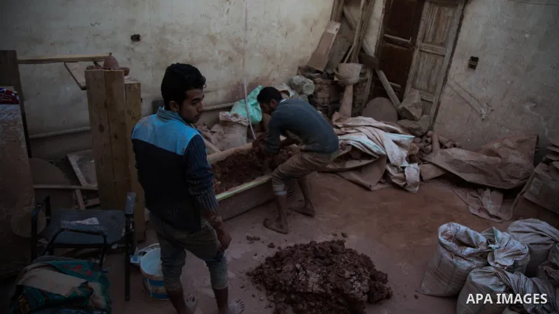 An Egyptian man, uses a pottery wheel to construct a clay vessel, at a pottery workshop in Cairo, on February 6, 2016. Pottery is an ancient and traditional craft in Gaza. Local workshops usually produce products such as...