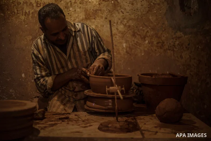 An Egyptian man, uses a pottery wheel to construct a clay vessel, at a pottery workshop in Cairo, on February 6, 2016. Pottery is an ancient and traditional craft in Gaza. Local workshops usually produce products such as...