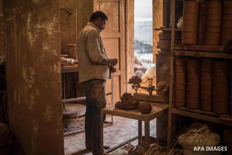 An Egyptian man works at a pottery workshop in Cairo, on February 6, 2016. Pottery is an ancient and traditional craft in Gaza. Local workshops usually produce products such as bowls, pitchers, flower pots, and vases. Ph...
