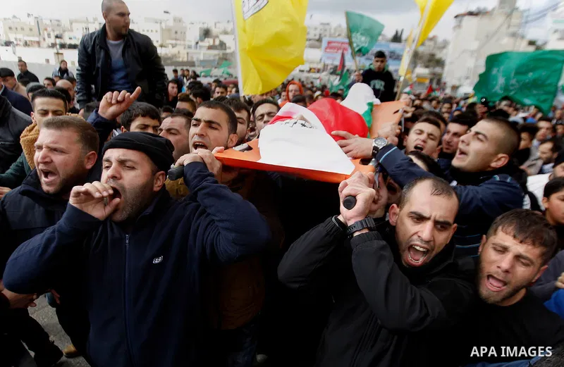 Mourners carry the body of Palestinian Haitham Al-Bau, who was shot and killed by Israeli soldiers, during his funeral, in the West Bank city of Hebron February 6, 2016. Israeli soldiers shot and killed Al-Bao, 17, in th...