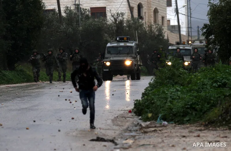 A Palestinian protester prepares his sling to hurl stones towards Israeli troops during clashes in the West Bank town of Qabatya, near Jenin February 6, 2016. On Wednesday, three young Palestinian men from Qabatya wieldi...