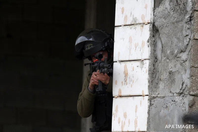A member of the Israeli security forces aims fire during clashes with Palestinian protestors in the village of Qabatiya, near the West Bank town of Jenin, during clashes on February 6, 2016. Three Palestinians from Qabat...