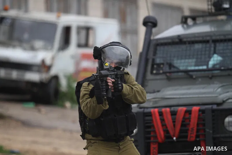 A member of the Israeli security forces aims fire during clashes with Palestinian protestors in the village of Qabatiya, near the West Bank town of Jenin, during clashes on February 6, 2016. Three Palestinians from Qabat...