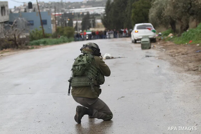 A member of the Israeli security forces aims fire during clashes with Palestinian protestors in the village of Qabatiya, near the West Bank town of Jenin, during clashes on February 6, 2016. Three Palestinians from Qabat...