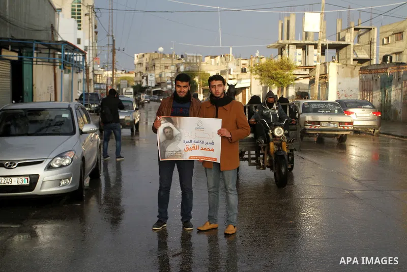 Palestinian journalists hold posters bearing portraits of Palestinian journalist Mohammed al-Qiq who is imprisoned in an Israeli jail during a protest in support of his hunger strike in Rafah in the southern Gaza strip o...