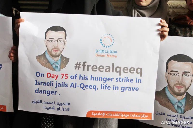 Palestinian journalists hold posters bearing portraits of Palestinian journalist Mohammed al-Qiq who is imprisoned in an Israeli jail during a protest in support of his hunger strike in Rafah in the southern Gaza strip o...