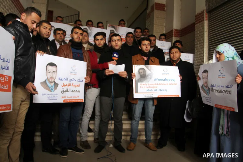 Palestinian journalists hold posters bearing portraits of Palestinian journalist Mohammed al-Qiq who is imprisoned in an Israeli jail during a protest in support of his hunger strike in Rafah in the southern Gaza strip o...