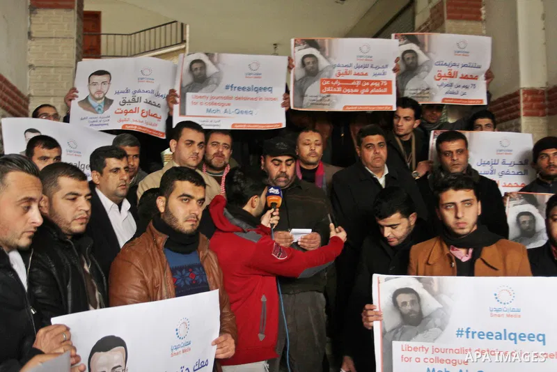 Palestinian journalists hold posters bearing portraits of Palestinian journalist Mohammed al-Qiq who is imprisoned in an Israeli jail during a protest in support of his hunger strike in Rafah in the southern Gaza strip o...