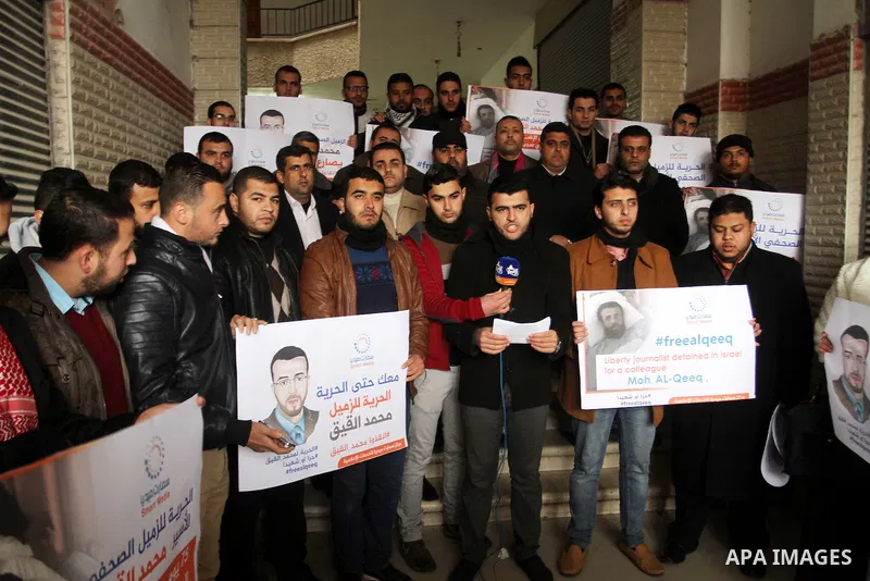 Palestinian journalists hold posters bearing portraits of Palestinian journalist Mohammed al-Qiq who is imprisoned in an Israeli jail during a protest in support of his hunger strike in Rafah in the southern Gaza strip o...