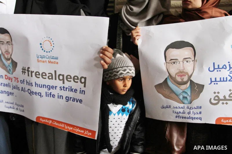 Palestinian journalists hold posters bearing portraits of Palestinian journalist Mohammed al-Qiq who is imprisoned in an Israeli jail during a protest in support of his hunger strike in Rafah in the southern Gaza strip o...