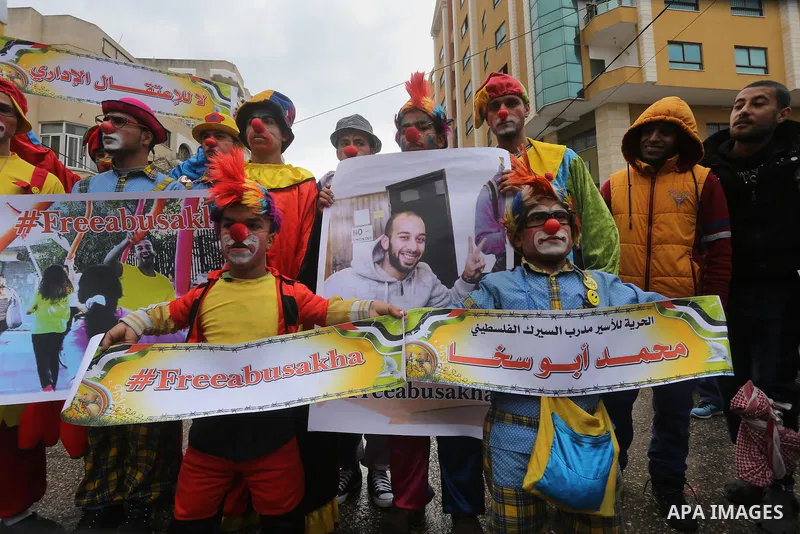 Palestinians dressed as clowns take part in a protest demanding release the prisoners in Israeli jails, in front of Red cross office, in Gaza city, on February 8, 2016. Photo by Mohammed Asad