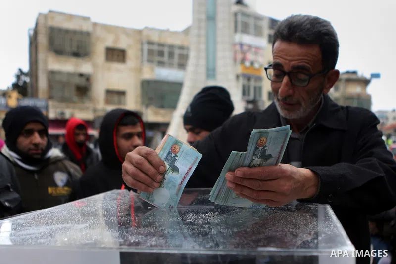 A Palestinian man donates money during a fundraising campaign aimed at rebuilding the families houses of Jerusalem Martyrs, after demolished by Israeli authorities in the West Bank city of Ramallah, on February 8, 2016....
