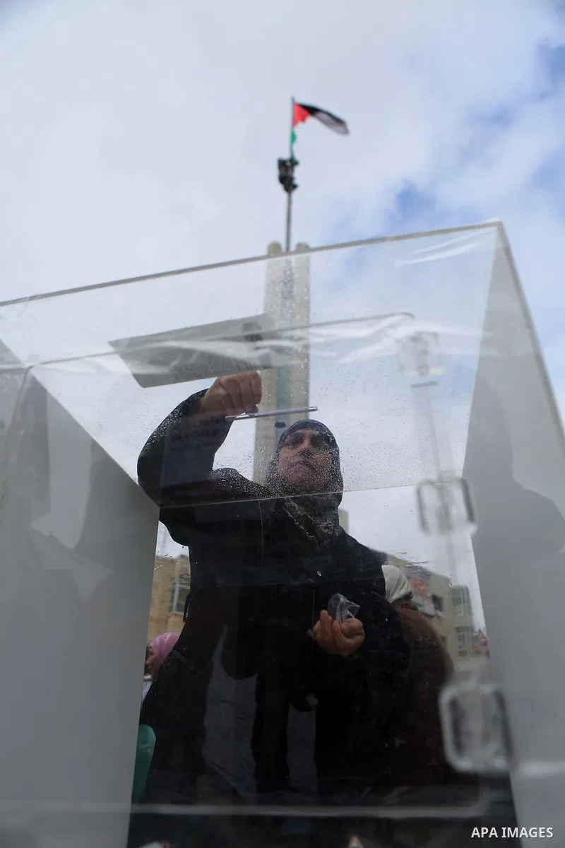 A Palestinian woman donates money during a fundraising campaign aimed at rebuilding the families houses of Jerusalem Martyrs, after demolished by Israeli authorities in the West Bank city of Ramallah, on February 8, 2016...