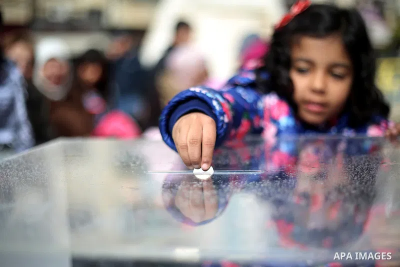 A Palestinian girl donates money during a fundraising campaign aimed at rebuilding the families houses of Jerusalem Martyrs, after demolished by Israeli authorities in the West Bank city of Ramallah, on February 8, 2016....